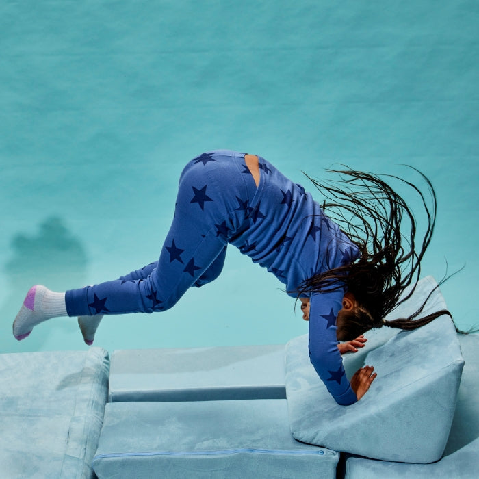 kid on play couch doing a flip
