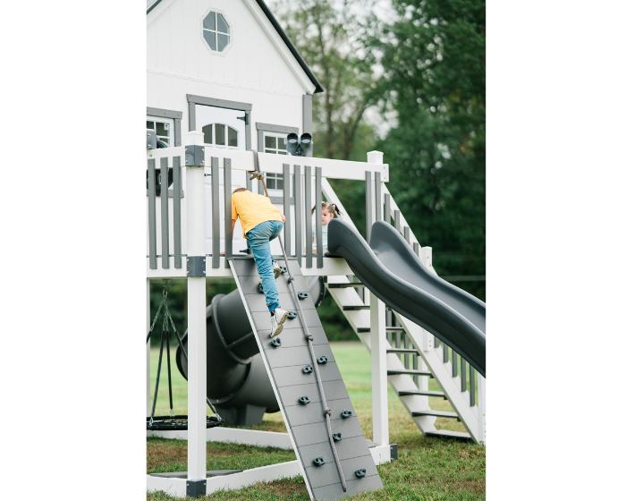 Children playing on a playground set with slides and climbing structures.