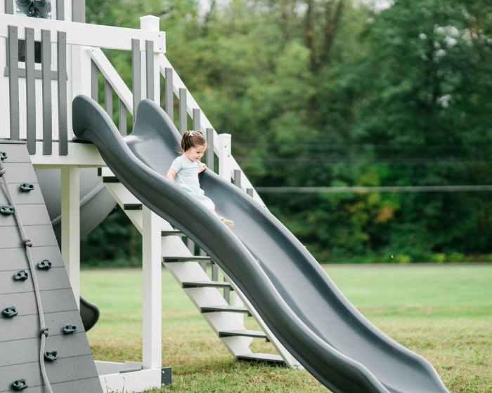 Child sliding down a playground slide on a sunny day