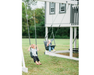 Two children on swings in front of a playhouse in a grassy area.